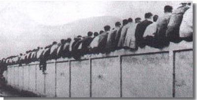 Fan Barcelona menyaksikan pertandingan dengan duduk pada bagian tembok tribun.